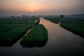 XINGHUA, CHINA: Canal in rapeseed field at morning