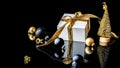 Xmas background gold. White gift box with golden ribbon, New Year balls and winter tree in Christmas composition on black Royalty Free Stock Photo