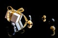 Xmas background gold. White gift box with golden ribbon, New Year balls and winter tree in Christmas composition on black Royalty Free Stock Photo