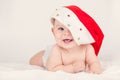 Xmas card with cute baby girl with santa hat on beige airy briht background with copy space