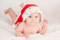 Xmas card with cute baby girl with santa hat on beige airy briht background with copy space