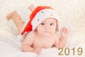 Xmas card with cute baby girl with santa hat on beige airy briht background with copy space