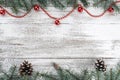 Xmas card. Old wooden Christmas background. Fir branches and cones. Red baubles and garlands. Top view Royalty Free Stock Photo