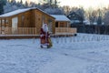 Xmas, cold, December. Santa Claus going with a bag of gifts in the winter on snow-covered field