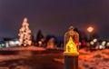 Christimas decoration, a enlighted lamp with a christmas tree in the backgroud at a snowy underground.