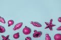 Xmas decorations horizontal background. Festive Christmas tree pink toys on light blue. Glossy glass baubles, cones