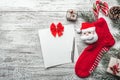 Xmas greeting card. Wooden background, painted white with a Christmas sock and Santa Claus. Candy colored in it. Handmade gift.