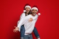 Xmas Mood. Cheerful Couple Wearing Santa Hats Having Fun On Red Background Royalty Free Stock Photo