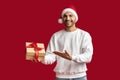 Xmas Offer. Handsome Arab Man In Santa Hat Pointing At Gift Box