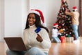 Xmas Online Shopping. Smiling lady using laptop showing credit card Royalty Free Stock Photo