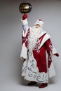 Xmas senior male in Santa costume with festive happy new year balloon on gray studio background
