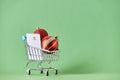 Xmas shopping, cart with two red christmas balls on a green background Royalty Free Stock Photo