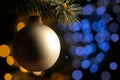 Xmas tree branch with pearl ball on the blurred light blue and golden spots background
