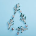 Xmas tree shape made of snowy fir branch and pinecone. Square composition, flat lay, view from above. Pastel blue background Royalty Free Stock Photo