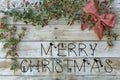 Christmas postcard for greetings. Metallic letters on natural wood background. Red, golden and white Xmas wallpaper