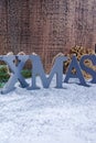 Xmas wooden letters and snowflake on shiny mirrored background,