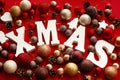 Xmas wooden word with red and gold baubles, ornaments, cones on Royalty Free Stock Photo