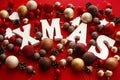 Xmas wooden word with red and gold baubles, ornaments, cones on Royalty Free Stock Photo