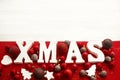 Xmas wooden word with red and gold baubles ornaments on white br Royalty Free Stock Photo