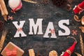 Xmax text on black wooden table with Christmas decorations, gift, candle, doll, stars, and bows Royalty Free Stock Photo