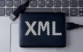 XML - acronum on an external drive in gray letters on the background of a laptop