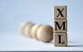 XML - acronym on a wooden block on a white background with wooden balls