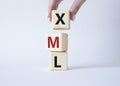 XML - Extensible Markup Language. Wooden cubes with word XML. Businessman hand. Beautiful white background. Business and
