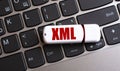 XML - the word on a white flash drive, lying on a black laptop keyboard