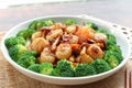 Stir fried Scallops in XO sauce of a white plate garnished with broccoli - close up view Chinese food on wood table Royalty Free Stock Photo