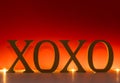 XOXO letters lighted on red background