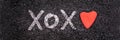 Xoxo written on the ground with a heart shapes stone Valentines day web banner