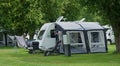 Xplore Caravan - Trailer with Awning on Campsite with trees,