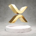 XRP cryptocurrency icon. Gold 3d rendered icon on white marble podium