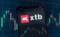 XTB polish stock broker shares rise or fall on stock exchange market - logo in mobile app on smartphone screen Royalty Free Stock Photo