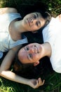 XTop view portrait of two young girl lying on grass having good time. Royalty Free Stock Photo