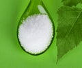 Xylitol birch sugar on green plastic spoon Royalty Free Stock Photo