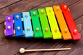 Xylophone on old brown wooden table. Children`s xylophone, painted in the colors of the rainbow Royalty Free Stock Photo