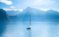A yacht against the backdrop of the mountains in Switzerland. Calm water and bright sunny day. Royalty Free Stock Photo
