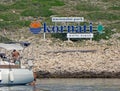 Yacht in the background of a signboard - logo: `Kornati` - National park of Croatia. Europe. Adriatic sea of Mediterranean area.