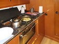 Yacht Bavaria caribian cruiser. Maritimes kitchen. Kabuz. Frying fish in the galley of a sailing yacht. A healthy diet and a Royalty Free Stock Photo