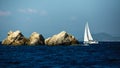 Yacht boat with white sails near the rocks in the Aegean sea. Travel. Royalty Free Stock Photo