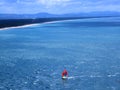 Yacht with bright sail, view from Mount Maunganui