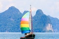 Yacht with colourful multi coloured sails