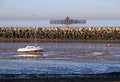 Yacht and derelict pier at low tide Royalty Free Stock Photo