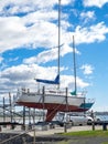 Yacht on dry dock stand being repaired with antifoul.