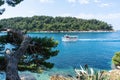 Yacht enters in the bay in a blue turquoise adriatic sea. Coast with green forest in Croatia with boat excursion Royalty Free Stock Photo