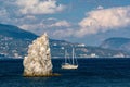 Yacht floats next to a rock Sail in Black sea Royalty Free Stock Photo