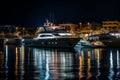 yacht lit up at night, anchored near illuminated marina Royalty Free Stock Photo