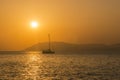 Yacht with lowered sail, sunset against the backdrop of mountains Royalty Free Stock Photo