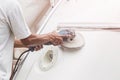 Yacht maintenance. A man polishing side of the white boat in the Royalty Free Stock Photo